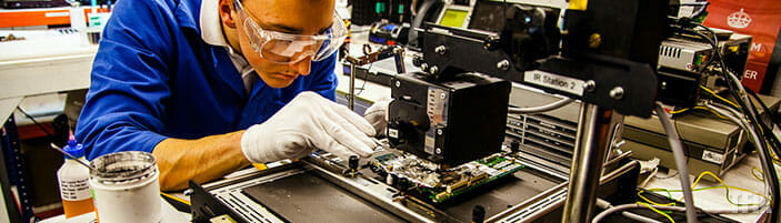 Engineer soldering industrial electronics
